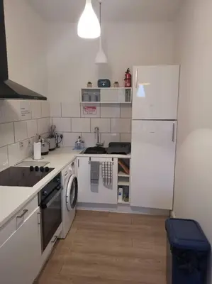 a white kitchen with a stove and a refrigerator at Castleview is a lovely flat in a listed building in Rothesay