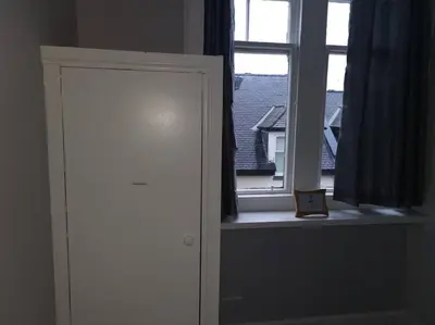 a room with a window and a door with a picture at Castleview is a lovely flat in a listed building in Rothesay