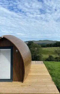 a wooden building with a door on a wooden deck at Endrick Escape - Luxury Glamping in Gartness
