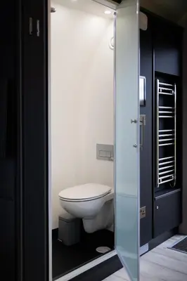 a bathroom with a toilet inside of a glass door at Endrick Escape - Luxury Glamping in Gartness