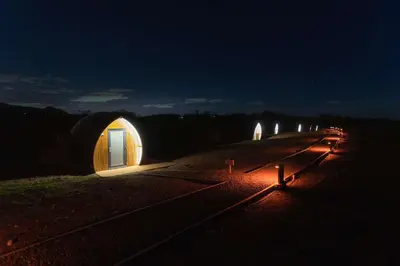 a row of domes in a field at night at Endrick Escape - Luxury Glamping in Gartness