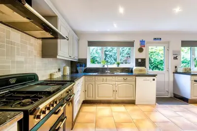 a kitchen with white cabinets and a stove top oven at Braemor 4 bedroom villa, all en-suite in Arrochar