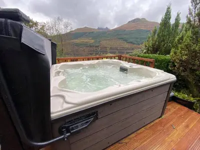 a hot tub sitting on top of a wooden deck at Braemor 4 bedroom villa, all en-suite in Arrochar