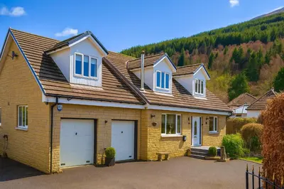 a house with two garage doors in a driveway at Gleann Fia House in Arrochar