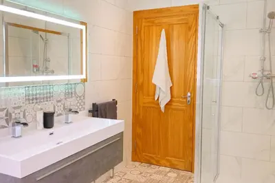 a bathroom with a white sink and a shower at Gleann Fia House in Arrochar