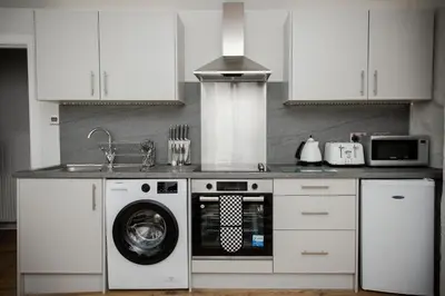a kitchen with a washing machine and a sink at 2 BDR House At Caledonia Luxe Stays Short Lets & Serviced Accommodation Crieff in Crieff