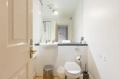 a white bathroom with a toilet and a sink at Amazing Castle View Apartment in Edinburgh
