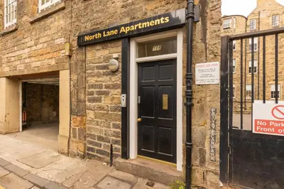 a brick building with a black door and a no parking sign at Amazing Castle View Apartment in Edinburgh