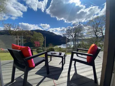 two chairs and a table on a deck with a view at the waterside - carrick castle - loch goil in Carrick