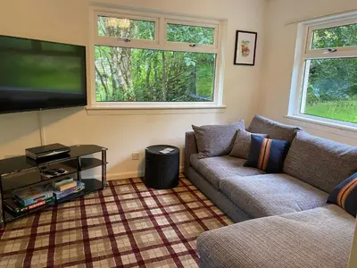 a living room with two couches and a flat screen tv at the waterside - carrick castle - loch goil in Carrick