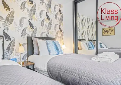 a bedroom with two beds and a sign that reads kiss living at Rothesay House by Klass Living Coatbridge in Coatbridge