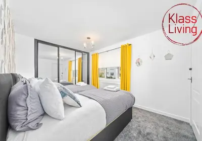 two beds in a bedroom with yellow curtains at Rothesay House by Klass Living Coatbridge in Coatbridge
