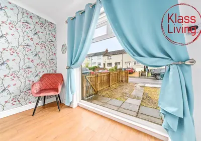a room with a window with blue curtains and a red chair at Rothesay House by Klass Living Coatbridge in Coatbridge