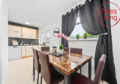 a kitchen and dining room with a table and chairs at Rothesay House by Klass Living Coatbridge in Coatbridge