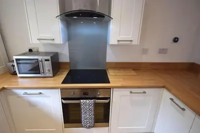a kitchen with a stove and a microwave at 1 Planetree Cottage - Loch View in Lochgoilhead