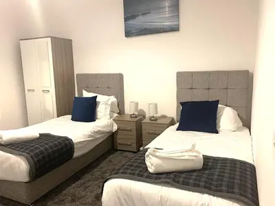 a bedroom with two beds with blue pillows at Glasgow, Bothwell, 3 bed, Suitable for Long Stays in Bothwell