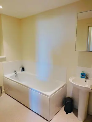 a white bath tub in a bathroom with a sink at No 2 - Modern 2 Bed Apartment Close to Gla Airport & M8 in Paisley