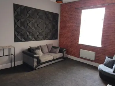 a living room with a couch and a brick wall at Moorburn Heights in Largs