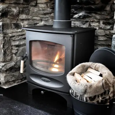 a wood burning stove with a basket of logs at Laburnam Villa - Luxury 4 bedroom accommodation in the heart of Killin in Killin