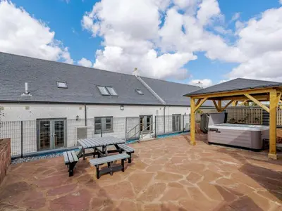 a patio with two benches and a picnic table at Westertonhill Newbuild Lodges with Private Hot Tub Hire Available in Balloch