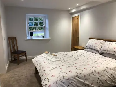 a bedroom with a bed and a window at The Studio at Pitmeadow Farm in Dunning