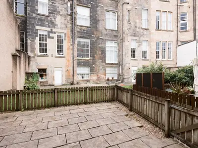 a wooden fence in front of a building at Beautiful Unique 3Bed Mews Cottage House - Pass the Keys in Glasgow