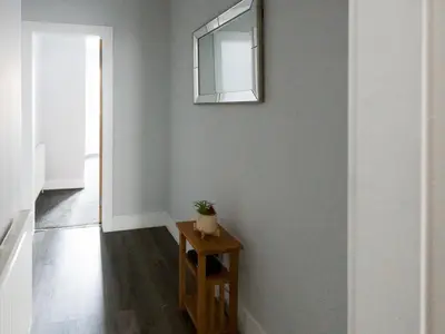 a hallway with a table and a mirror on a wall at Superb 1Bed Flat in Fabulous West End - Pass the Keys in Glasgow