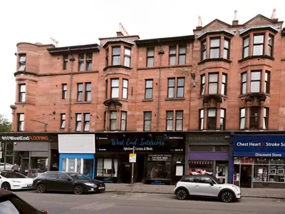 a large brick building with cars parked in front of it at Superb 1Bed Flat in Fabulous West End - Pass the Keys in Glasgow