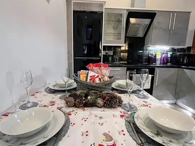 a table with plates and wine glasses on a kitchen at Hayloft at Bonnyside House in Bonnybridge