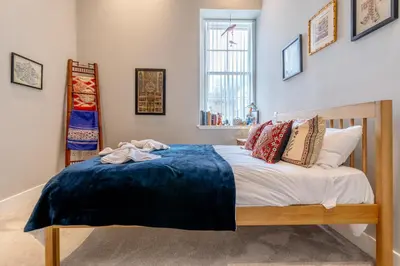 a bedroom with a bed with a blue blanket on it at Unique Two Bed Holiday Home in Edinburgh in Edinburgh
