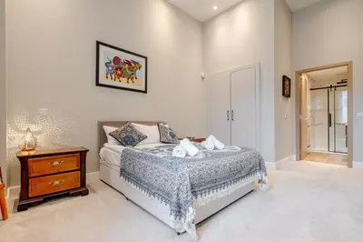 a bedroom with a bed and a wooden nightstand at Unique Two Bed Holiday Home in Edinburgh in Edinburgh