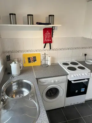 a small kitchen with a stove and a sink at 1-Bedroom Chalet at Maryville Caravan Site - Uddingston, Glasgow in Uddingston