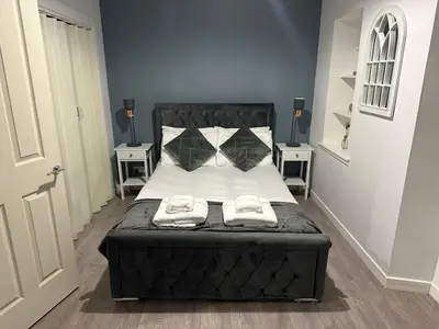a bedroom with a large bed with two night stands at One bedroom flat in Oban town centre in Oban