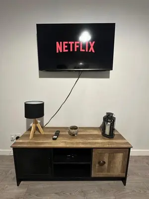 a netflix sign on a wall with a coffee table at One bedroom flat in Oban town centre in Oban
