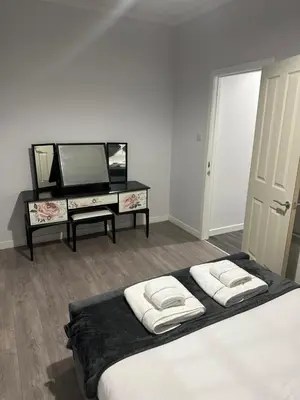 a white room with a bed and a television at One bedroom flat in Oban town centre in Oban