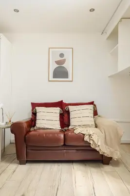 a brown leather couch sitting in a living room at Central Studio Near Usher Hall & Edinburgh Castle in Edinburgh
