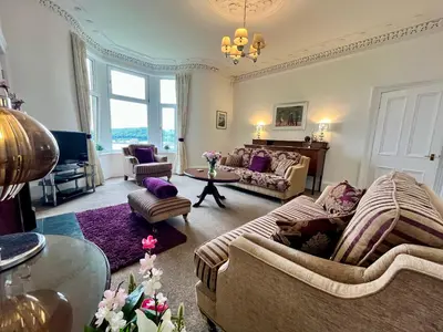 a living room with two couches and a table at Dairsie Sea View in Rothesay