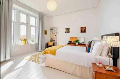a white bedroom with a large bed and a window at Dairsie Sea View in Rothesay