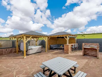 a patio with a gazebo and a picnic table at Westertonhill Lodge - 4 Bedrooms Sleeps 10 with Private Hot Tub Hire Available in Balloch