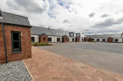 a row of houses with a driveway in front at Westertonhill Lodge - 4 Bedrooms Sleeps 10 with Private Hot Tub Hire Available in Balloch