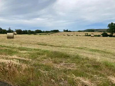 a field full of hay bales in a field at Westertonhill Lodge - 4 Bedrooms Sleeps 10 with Private Hot Tub Hire Available in Balloch