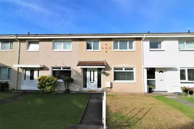 a brick house with white doors and a yard at Signature - Morland House in East Kilbride