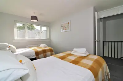 a bedroom with two beds and a window at Signature - Morland House in East Kilbride