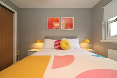 a bedroom with a large bed with two lamps at Signature - Carnbroe House in Old Monkland