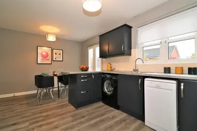 a kitchen with a washer and dryer in it at Signature - Carnbroe House in Old Monkland