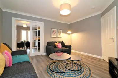 a living room with a couch and a table at Signature - Carnbroe House in Old Monkland