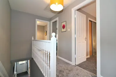 a hallway with a white staircase and a ceiling at Signature - Carnbroe House in Old Monkland