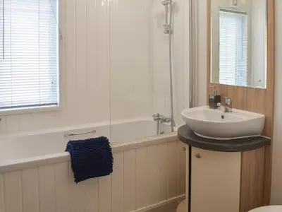 a bathroom with a sink and a bath tub and a sink at Devin Lodge in Dollar