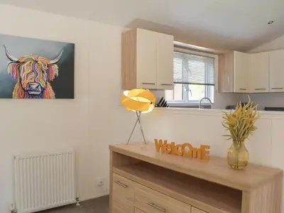 a kitchen with a painting of a cow on the wall at Devin Lodge in Dollar