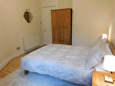a bedroom with a bed and a wooden door at Beautiful & spacious 2 bed apt in Glasgow West End in Glasgow